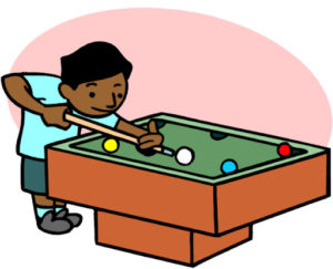 Student standing in front of a pool table with billard balls playing pool billard