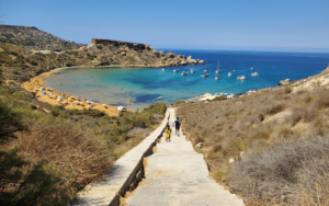 Tourists going downstairs to the natural beach of Għajn Tuffieħa in Malta