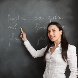 Image of a woman holding a pen and writing Spanish words on board as part of Spanish course in Dublin.