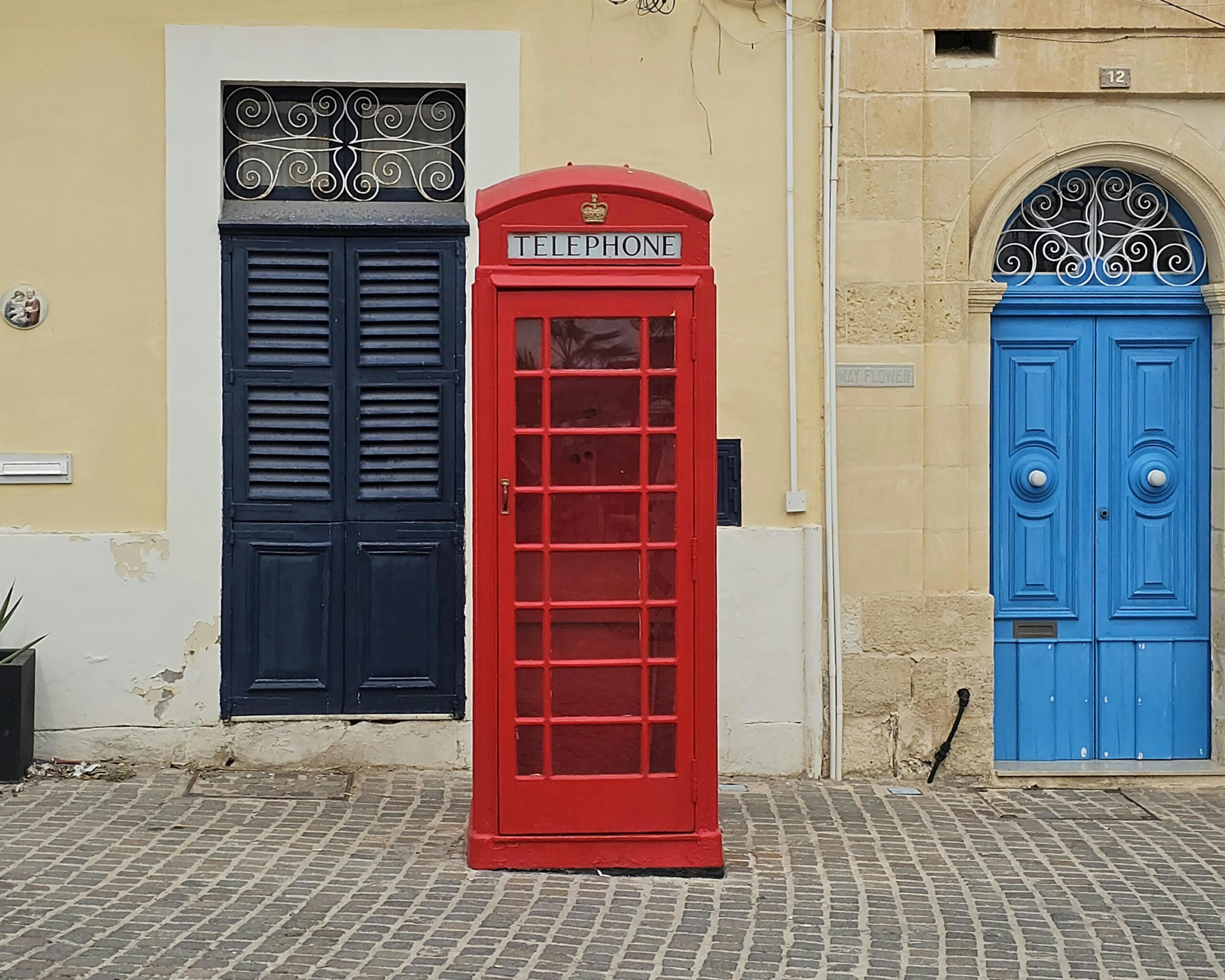 This is a red English telephone box but it is located in a Malta street.