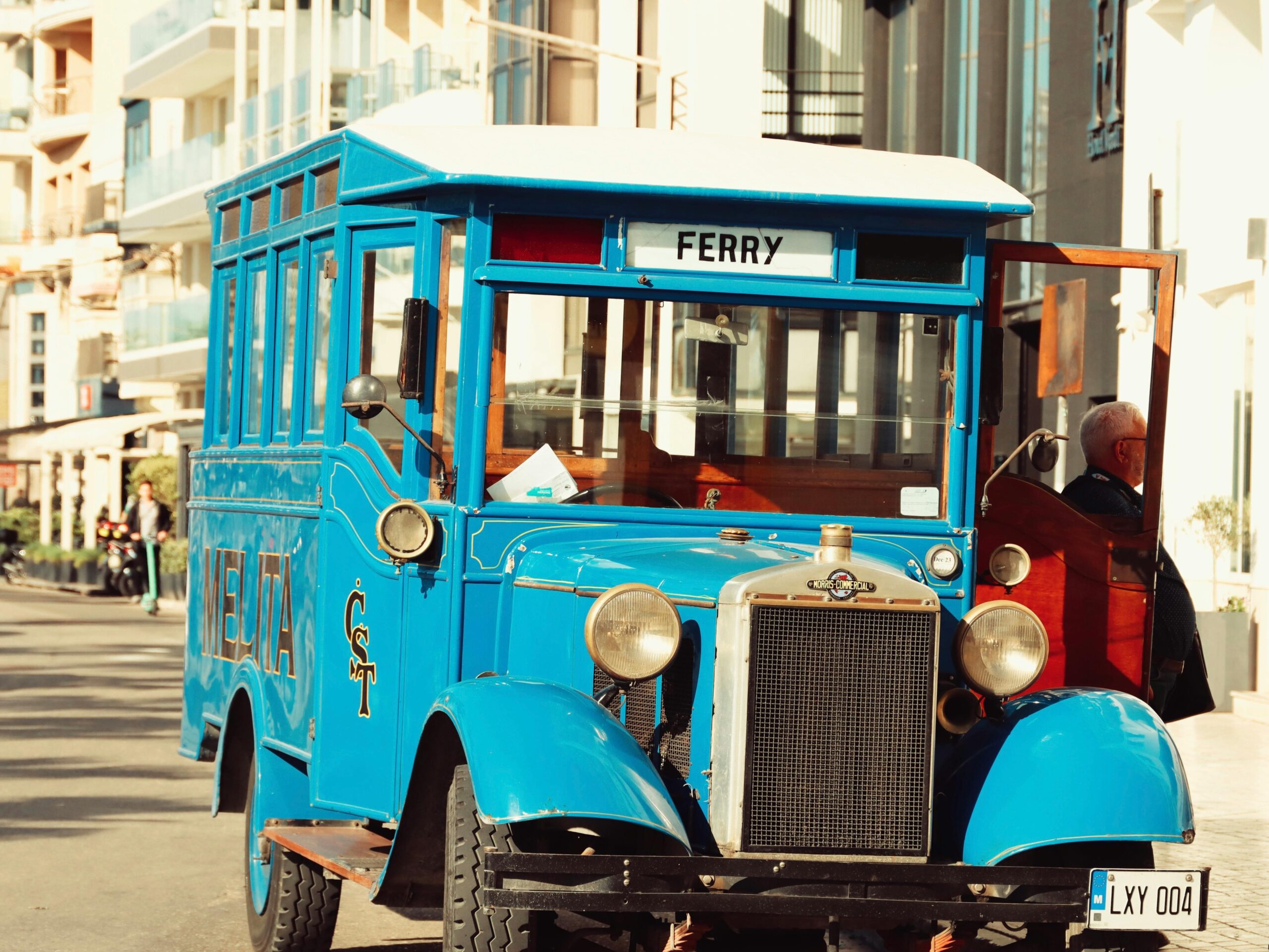 This picture shows an old vintage blue bus in Malta in the middle of the street.