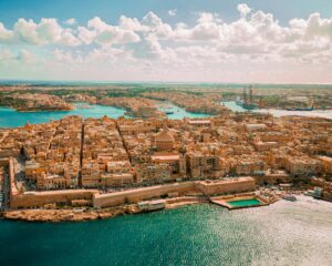 Picture of the malta city with with stones and blue and green seas. very sunny picture.