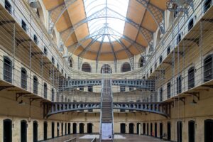 Interior view of Kilmainham Gaol in Dublin, featuring the historic prison cells with their austere, stone walls and barred windows.