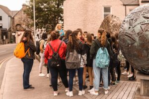 Students from Atlas Junior Clare listening to the group leader during their tour of Ennis town.