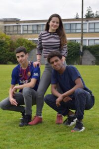 Three students posing outdoors as part of the sports activities.