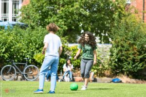 Students at Atlas Junior summer programme playing football.