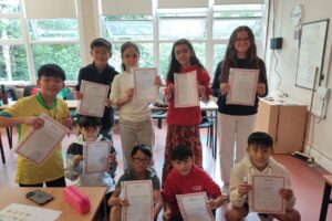 Junior students holding graduation certificates in Dublin.