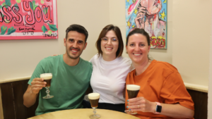 Three Erasmus+ teacher training participants cheering in their t-shirts, which feature the colors of the Irish flag, celebrating the completion of their course.