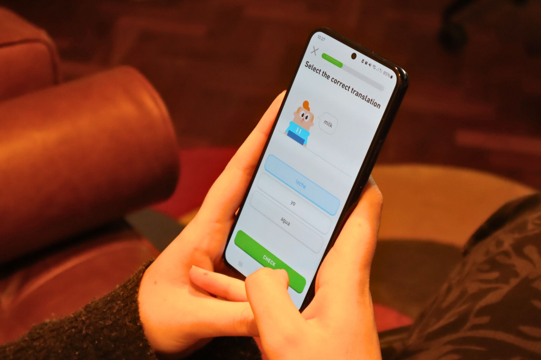 Person using Duolingo app on a smartphone, illustrating language learning with interactive games and exercises.