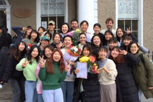 Group of students celebrating English course completion at Atlas Language School.