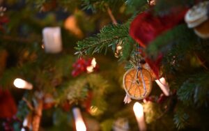 Close-up of a dried orange slice used as a Christmas decoration on a tree, with a warm, festive atmosphere and subtle bokeh background