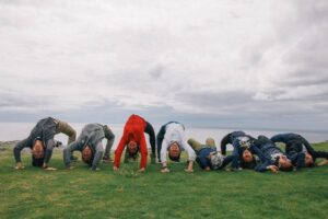 Group of Atlas Language School students doing playful backbends on the cliffs of the Aran Islands, enjoying a fun and scenic day by the sea.
